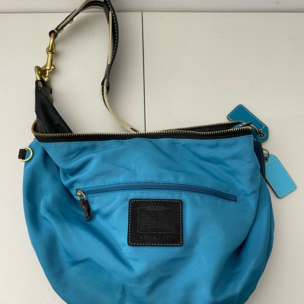 Woman’s teal and black coach bag